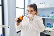 © Krakenimages.com - Young beautiful plus size woman scientist putting plant with tweezers on bottle at pharmacy