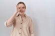 © Krakenimages.com - Young caucasian woman wearing casual shirt doing ok gesture with hand smiling, eye looking through fingers with happy face.