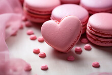 A pink macaron in the shape of a heart on a gentle gray textile