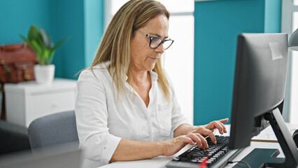 Sticker - Middle age hispanic woman business worker using computer working at the office