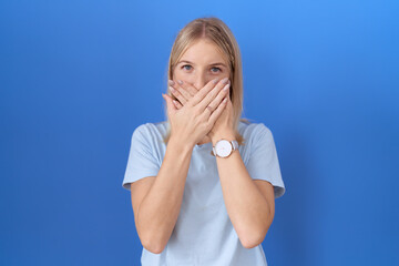 Sticker - Young caucasian woman wearing casual blue t shirt shocked covering mouth with hands for mistake. secret concept.