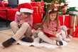© Krakenimages.com - Brother and sister drawing on notebook sitting on floor by christmas tree at home