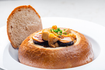 Wall Mural - stew with pork meat, chickpeas and sausge in loaf of bread