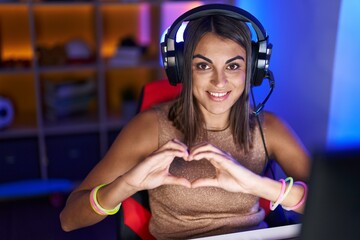 Poster - Young beautiful hispanic woman streamer smiling confident doing heart symbol with hands at gaming room