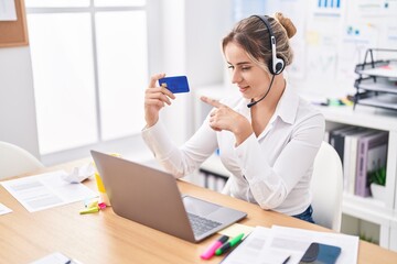 Wall Mural - Young blonde woman call center agent holding credit card working at office