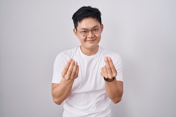 Sticker - Young asian man standing over white background doing money gesture with hands, asking for salary payment, millionaire business