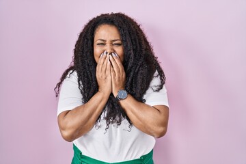 Poster - Plus size hispanic woman standing over pink background laughing and embarrassed giggle covering mouth with hands, gossip and scandal concept