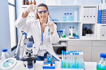 Sticker - Young hispanic woman working at scientist laboratory smiling making frame with hands and fingers with happy face. creativity and photography concept.