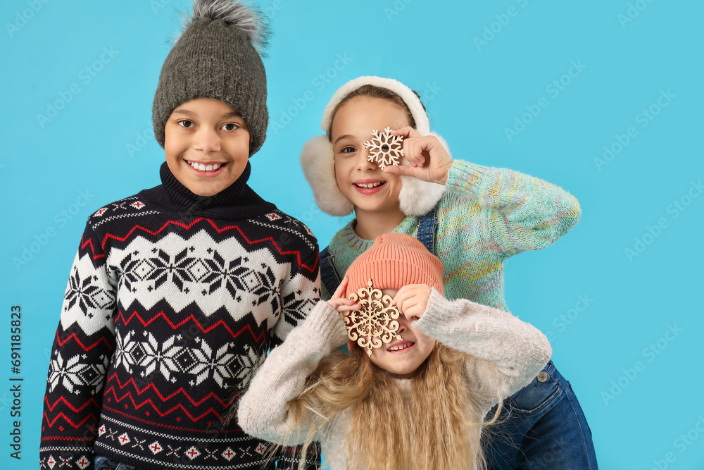 Cute children in winter clothes on blue background