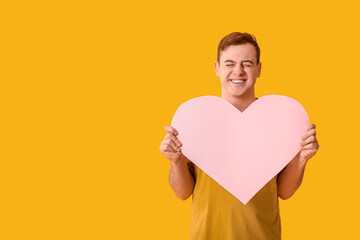 Sticker - Happy young man with pink paper heart on yellow background