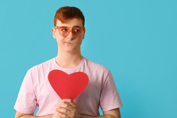 Sticker - Young man with red paper heart on blue background