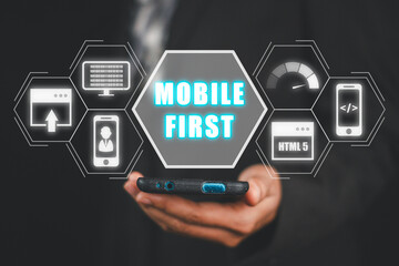 Wall Mural - mobile first concept, business woman using mobile phone with mobile first icon on virtual screen, we