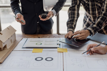 Construction engineers work on blueprints to build large commercial buildings with engineering tools and construction ideas for houses or office buildings in real estate. Close-up photo