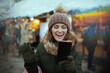 © Alliance - smiling modern woman at winter fair in city having video call