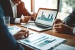 © Wuttichai - Dynamic business meeting unfolds in modern office setting. Executives engage in teamwork analyzing financial charts and graphs. professional reflecting of technology planning and investment strategies