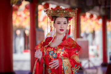 Portrait happiness young beautiful Asian woman wear red cheongsam dress costume holding red fan on hand celebration on Chinese festival.