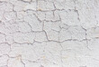 Cracked plaster on a white wall as an abstract background. Texture