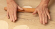 A woman rolls out dough with a rolling pin