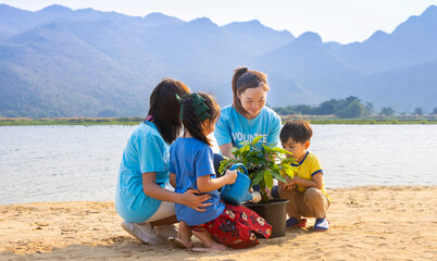 Wall Mural - Team of volunteer worker group teaching children to planting tree in charitable social work on forest rewilding NGO work for fighting climate change and global warming in the coastline habitat concept