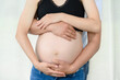 A pregnant woman's belly is exposed, a married couple is waiting for the birth of their child.