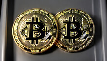 Two golden  pieces of cryptocurency on black background, bitcoin pieces