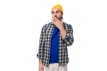 Wall Mural - cute surprised young hipster man in yellow cap and shirt on white background with copy space