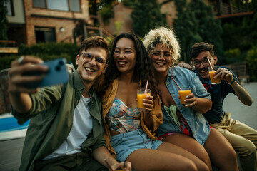 Multiethnic friends gather around the pool, drinks in hand, creating a vibrant atmosphere of laughter and camaraderie