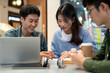 © bongkarn - Group of young Asian college students is working on a co-project while sitting in a cafe together.