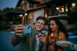 © La Famiglia - A multiethnic couple share pasta and laughter outdoors