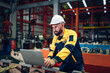© kelvn - Industrial man engineer wear uniform and helmet using laptop are checking system machine at factory. Workers industrial factory. Machine maintenance technician operation concept.
