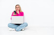 © luismolinero - Young caucasian woman with laptop sitting on the floor thinking and sending a message