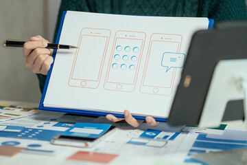 Creative male web designer planning application development for web mobile phone at modern workplace.