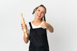 Young woman holding a rolling pin isolated on white background with thumbs up because something good has happened