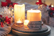 Cozy winter composition with burning candles and Christmas decor details.