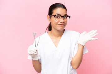 Wall Mural - Dentist Colombian woman isolated on pink background having doubts while raising hands