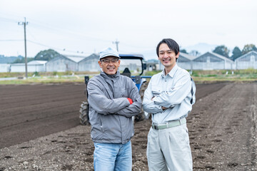 畑に立つ親子農家
