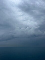 dark rainy clouds at the sea, cloudy seascape, deep blue sea horizon