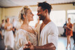 © VisualProduction - Afro american and caucasian dancers dancing in the dancing school, smiling. Relaxed atmosphere, couples teaching how to dance with instructor.