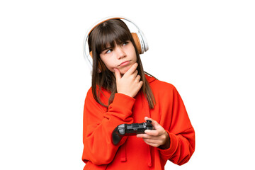 Wall Mural - Little caucasian girl playing with a video game controller over isolated background having doubts