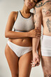 © LIGHTFIELD STUDIOS - cropped view of man with tattoos next to his african american girlfriend looking at camera