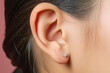 Asian girl with closeup of her ear. Hearing loss and deafness concept