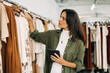 © (JLco) Julia Amaral - Clothing store owner doing a stock take with a tablet