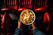 cinematic moment captured from above, with a viewer holding a bowl of popcorn in a theater setting, ready for the film to start