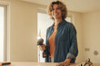 © Jacob Lund - Happy homeowner smiling while upgrading her kitchen with diy renovation work