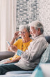 © Daniel - Elderly grandfather and grandmother spend time having fun using smartphone apps, middle-aged wife enjoy online entertainments, taking selfie with old husband, older generation and modern tech concept.