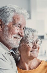 Canvas Print - Dreamy middle aged senior loving retired family couple looking in distance, planning common future or recollecting memories, enjoying peaceful moment relaxing together on cozy sofa in living room.