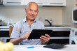 Grandfather man doing online payment from digital tablet