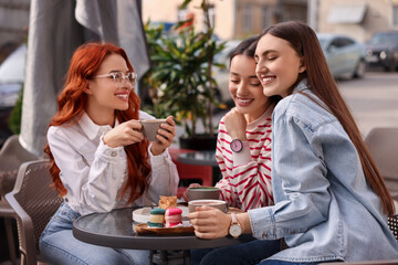 Canvas Print - Happy friends talking and drinking coffee in outdoor cafe