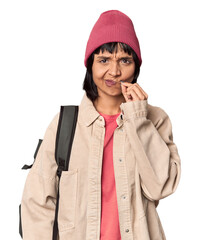 Wall Mural - Young student with backpack and beanie in studio raising fist after a victory, winner concept.