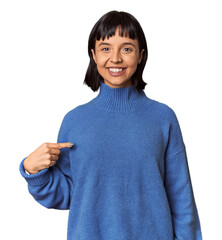 Wall Mural - Young Hispanic woman with short black hair in studio person pointing by hand to a shirt copy space, proud and confident